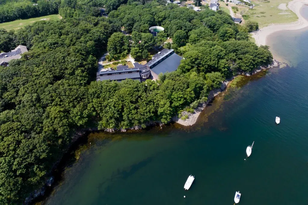 An aerial view the ocean next to a college campus